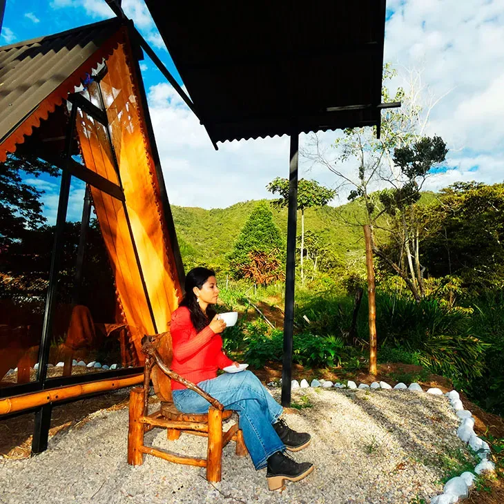 Disfruta de una taza de café afuera de la glamping, con una serena vista al río que proporciona un momento perfecto de relajación.
