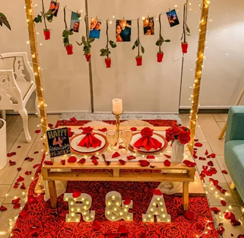 Paquete romántico con guirnalda de luces colgantes, velitas, fotos impresas, iniciales luminosas, botella de vino Gran Rosé TABERNERO y pizarra luminosa personalizada.