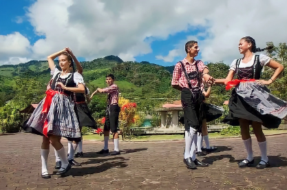 Escena festiva en la Colonia Alemana de Oxapampa, donde los participantes visten trajes tradicionales de la región mientras disfrutan de un animado baile.
